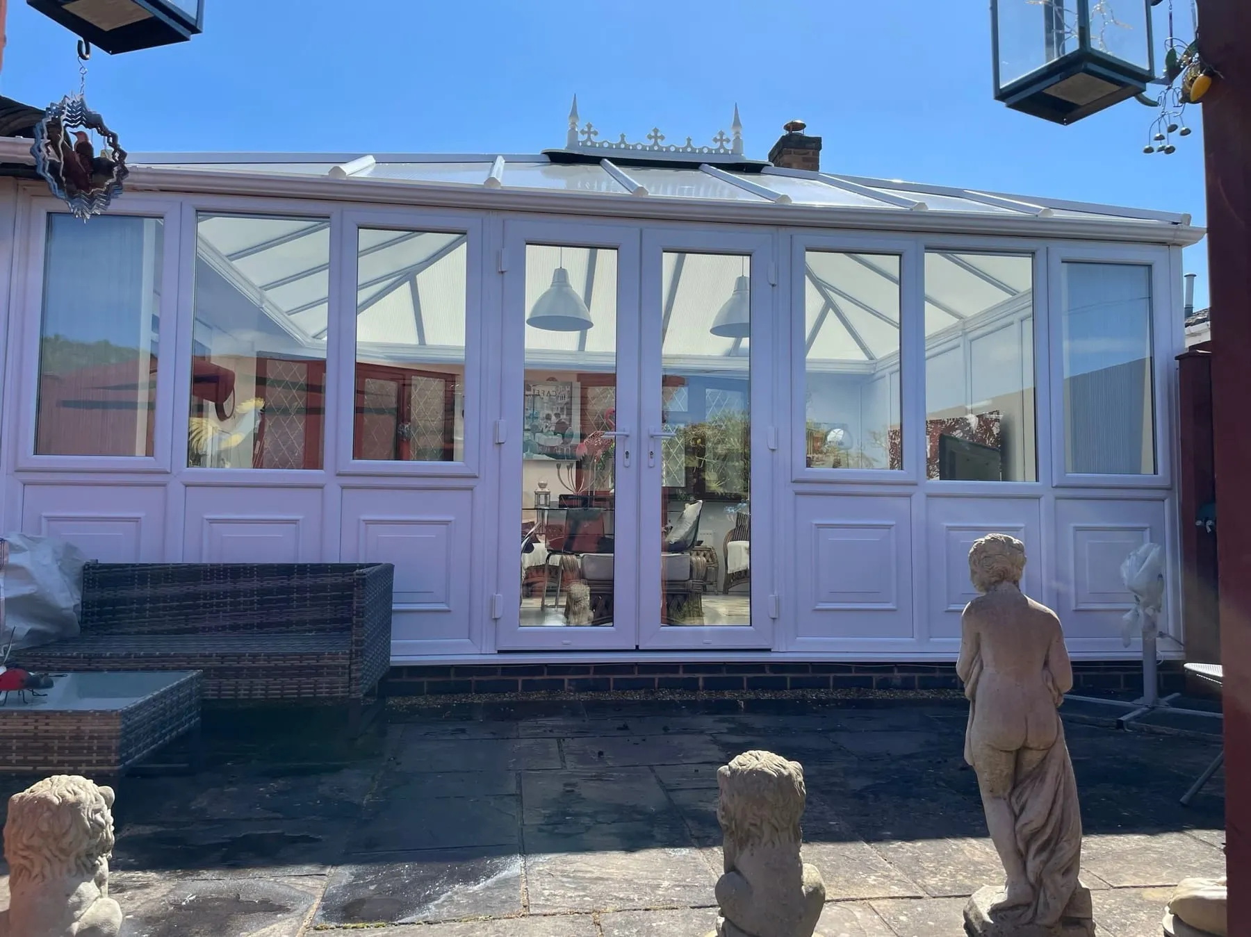 Clean glass conservatory roof with the ridge and finial washed down