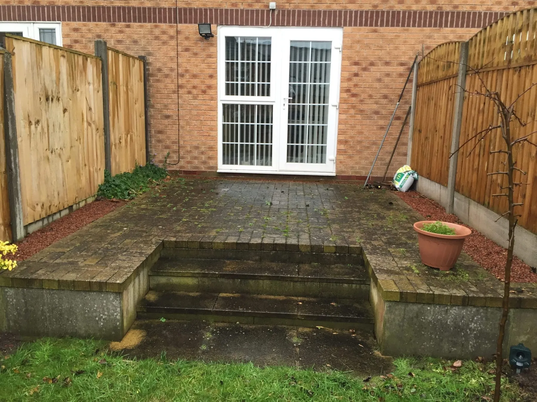 Block-paved driveway mid-clean, with the jet-washed section clearly lighter than the rest