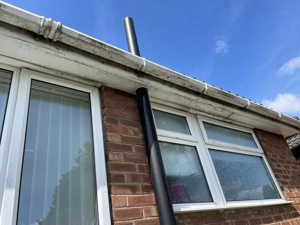 A cleared gutter run with the downpipe and hopper checked for blockages