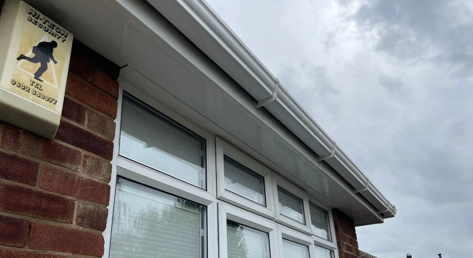 The same soffit and gutter after cleaning, clean white uPVC